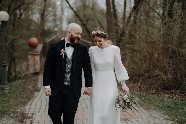 Brautpaar geht lachend bei den Paarfotos in der Therme Blumau