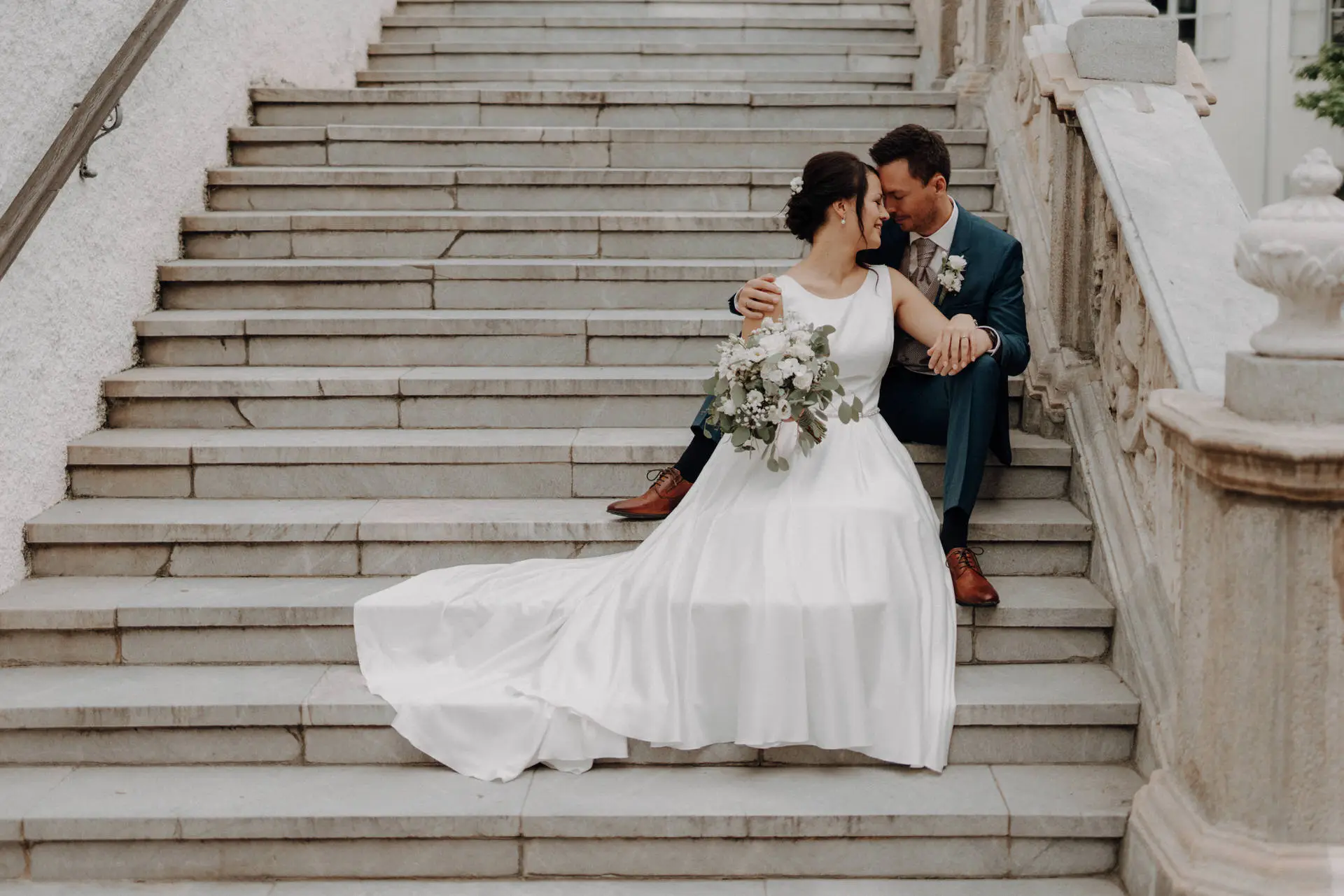Brautpaar sitzt auf der Stiege zur Basilika in Weiz